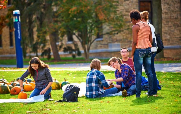 Colgate students carve pumpkins on the Academic Quad