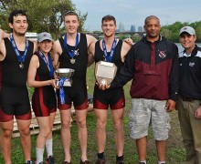 Men's Rowing team poses in uniform with their trophy