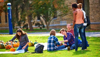 Colgate students carve pumpkins on the Academic Quad