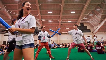 Students joust with foam swords in Sanford Fieldhouse