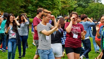 Students look through their hands during an ice breaking activity