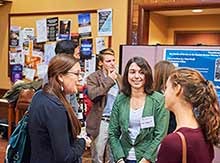 Students chat with alumni at poster presentation