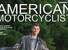 Ben Rich '99 standing by his electric motorcycle on the cover of American Motorcyclist