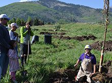 Jason Barto ’89 leads a group planting trees with a mountain in the background
