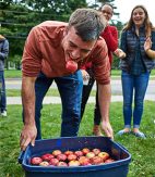 Student comes up with an apple in his mouth after bobbing for apples