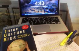Third Culture Kids book, laptop, and paper with highlighter