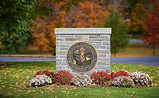 A stone marker on campus featuring the Colgate seal